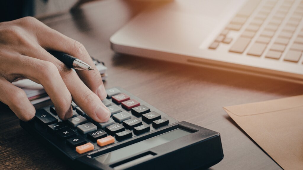 Calculadora sobre mesa de escritório representando negociação judicial de dívida bancária